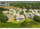 Aerial view of a home with a screened-in patio, lush landscaping, and a pond in the background at 27223 Nostalgia Dr, Leesburg, FL 34748