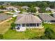 Aerial view of a home featuring a large screened lanai, patio with furniture, and well-maintained landscaping at 27223 Nostalgia Dr, Leesburg, FL 34748