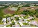 An aerial view of a residential community with a pond, surrounded by lush greenery and well-maintained homes at 27223 Nostalgia Dr, Leesburg, FL 34748