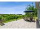 Paver patio with table, chairs, and umbrella overlooks the lush backyard at 27223 Nostalgia Dr, Leesburg, FL 34748