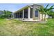 Spacious backyard featuring a screened lanai and lush landscaping at 27223 Nostalgia Dr, Leesburg, FL 34748