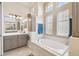 Bright bathroom with large vanity, cabinets, soaker tub, and many windows providing natural light at 27223 Nostalgia Dr, Leesburg, FL 34748