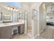 Bright bathroom with double vanity, glass enclosed shower, lots of counter space, and access to other rooms at 27223 Nostalgia Dr, Leesburg, FL 34748