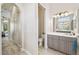 Bathroom featuring a vanity with plenty of cabinets, a toilet in an enclosed room and view to hallway at 27223 Nostalgia Dr, Leesburg, FL 34748