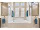 Bright bathroom featuring a large tub with tiled surround, cabinets, and natural light from multiple windows at 27223 Nostalgia Dr, Leesburg, FL 34748