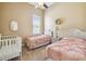 Cozy bedroom with two twin beds, crib, and natural light at 27223 Nostalgia Dr, Leesburg, FL 34748