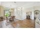Dining room with a chandelier, window, and stylish wicker dining set adjacent to front entrance at 27223 Nostalgia Dr, Leesburg, FL 34748