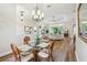 Dining room with a chandelier and wicker dining set adjacent to living area at 27223 Nostalgia Dr, Leesburg, FL 34748