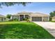 Charming single-story home with a well-manicured lawn and a three-car garage at 27223 Nostalgia Dr, Leesburg, FL 34748