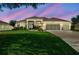 Beautifully landscaped home with well-manicured lawn and three-car garage, creating inviting curb appeal at 27223 Nostalgia Dr, Leesburg, FL 34748