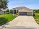 Lovely single-story home featuring a spacious driveway and a three-car garage at 27223 Nostalgia Dr, Leesburg, FL 34748