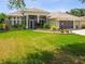 Inviting single-story home with a well-maintained lawn and a screened-in front porch at 27223 Nostalgia Dr, Leesburg, FL 34748