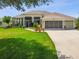 Attractive single-story home with a lush green lawn and a screened entry at 27223 Nostalgia Dr, Leesburg, FL 34748