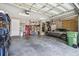 Well-organized garage with ample storage space and parking for a car and golf cart at 27223 Nostalgia Dr, Leesburg, FL 34748