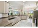 Kitchen with stainless steel appliances and views to dining area and lush landscape at 27223 Nostalgia Dr, Leesburg, FL 34748