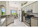 Kitchen featuring stainless appliances and breakfast nook with green outdoor views at 27223 Nostalgia Dr, Leesburg, FL 34748