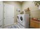 Functional laundry room with modern washer and dryer units and storage shelves at 27223 Nostalgia Dr, Leesburg, FL 34748