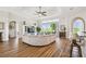 Open living area features wood floors, large windows offering a view, and access to kitchen bar seating at 27223 Nostalgia Dr, Leesburg, FL 34748