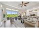 Bright living room featuring a ceiling fan and large sliding doors showcasing a serene outdoor view at 27223 Nostalgia Dr, Leesburg, FL 34748
