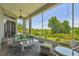 Inviting screened porch with wicker furniture overlooking lush backyard at 27223 Nostalgia Dr, Leesburg, FL 34748