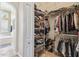 Walk-in closet featuring shelves, hanging rods, and access to a spa-like bathroom at 27223 Nostalgia Dr, Leesburg, FL 34748