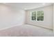 Bright, spacious bedroom featuring a large window, plush carpeting, and minimalist design at 3309 Grande Heron Dr, St Cloud, FL 34773