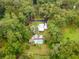 Aerial view of the residence and pool nestled among a densely wooded lot at 3341 Se 45Th St, Ocala, FL 34480