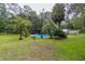 A picturesque backyard featuring a swimming pool, covered deck, and mature trees at 3341 Se 45Th St, Ocala, FL 34480