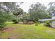 Lush backyard with a covered deck overlooking the pool, plus a covered patio with outdoor dining area and landscaping at 3341 Se 45Th St, Ocala, FL 34480