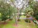 Exterior view of the home and driveway surrounded by mature trees and lush landscaping at 3341 Se 45Th St, Ocala, FL 34480