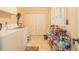 Functional laundry room equipped with a washer, dryer, and ample storage shelves at 3341 Se 45Th St, Ocala, FL 34480