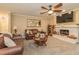 Inviting living room features a fireplace, ceiling fan, and comfortable leather sofas at 3341 Se 45Th St, Ocala, FL 34480