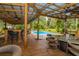 Outdoor seating near a beautiful pool, shaded by a wooden pergola, perfect for entertaining guests at 3341 Se 45Th St, Ocala, FL 34480
