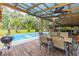 Inviting pool area with a covered deck, outdoor seating, and a grill, perfect for entertaining and relaxation at 3341 Se 45Th St, Ocala, FL 34480