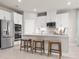 Bright kitchen with white cabinets, stainless steel appliances, a tile backsplash, and breakfast bar seating at 1278 Whispering Ln, Minneola, FL 34715