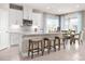 Stylish kitchen with white cabinetry, a center island with seating, and an adjacent dining area with lots of light at 1278 Whispering Ln, Minneola, FL 34715