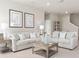 Bright living room featuring two sofas, a coffee table, and neutral tones creating a cozy atmosphere at 1278 Whispering Ln, Minneola, FL 34715