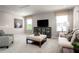 Spacious living room featuring a plush sofa, patterned ottoman, tv and 2 windows at 1278 Whispering Ln, Minneola, FL 34715