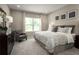 Bright main bedroom with large window, dresser, chair and plush patterned bedding at 1278 Whispering Ln, Minneola, FL 34715