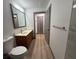 Bathroom with a wooden vanity, decorative mirror, and light tile flooring at 2963 Poplar Ave, Leesburg, FL 34748