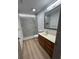 Bathroom featuring a marble-tiled shower, wooden vanity, and sleek design at 2963 Poplar Ave, Leesburg, FL 34748