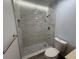 Close up of the walk-in shower featuring marble-look tile and pebble flooring, including the toilet at 2963 Poplar Ave, Leesburg, FL 34748