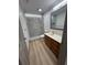 Modern bathroom featuring a walk-in shower, hard surface flooring, and wood cabinet at 2963 Poplar Ave, Leesburg, FL 34748