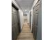 Hallway with multiple closets and neutral paint leading to other rooms of the house at 2963 Poplar Ave, Leesburg, FL 34748