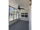 View of the renovated lanai features a ceiling fan, lighting fixtures, and windows offering ample natural light at 2963 Poplar Ave, Leesburg, FL 34748