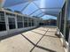 Enclosed lanai featuring a concrete patio, screened-in windows, and a high-pitched ceiling at 2963 Poplar Ave, Leesburg, FL 34748