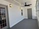 Lanai featuring freshly painted gray concrete floors, a new ceiling fan, and natural light through windows at 2963 Poplar Ave, Leesburg, FL 34748
