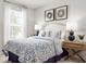 Cozy bedroom with a comfortable bed, bright window, matching lamps and stylish blue and white bedding at 1203 Turtle Island Rd, Lady Lake, FL 32159