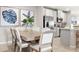 Comfortable dining area, adjacent to the kitchen, has seating for six and modern botanical art at 1203 Turtle Island Rd, Lady Lake, FL 32159