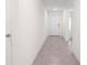 Bright hallway with neutral walls and tile flooring leading to the front door at 8471 Clearway Dr, Wildwood, FL 34785